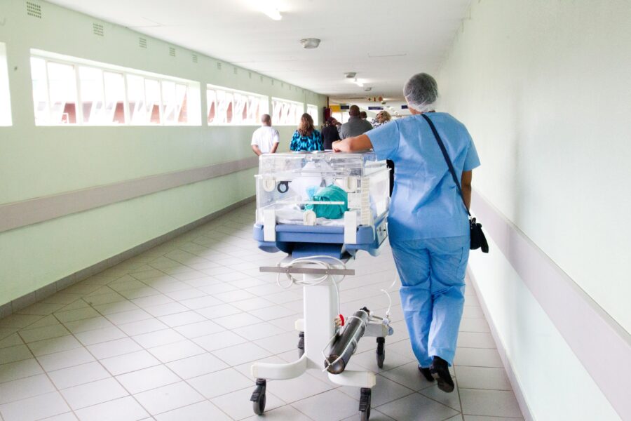 Woman in hopital walking with newborn. Healthcare safety.
